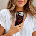 Midnight Rose matte case on iPhone 17 Pro Max, styled with a glass of red wine and deep shadows on a dark marble surface.